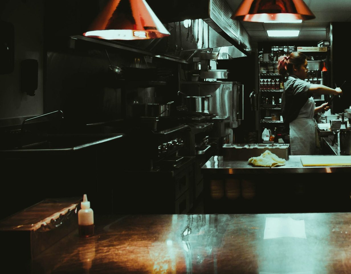 Cuisine d'un restaurant, avec un chef en train de préparer des plats.